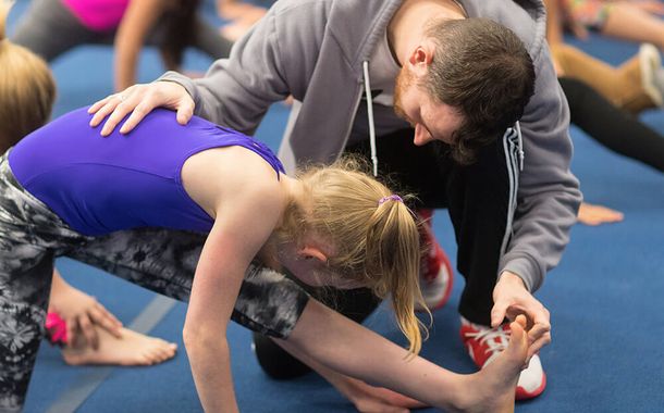 Gymnastics East coach helping a student