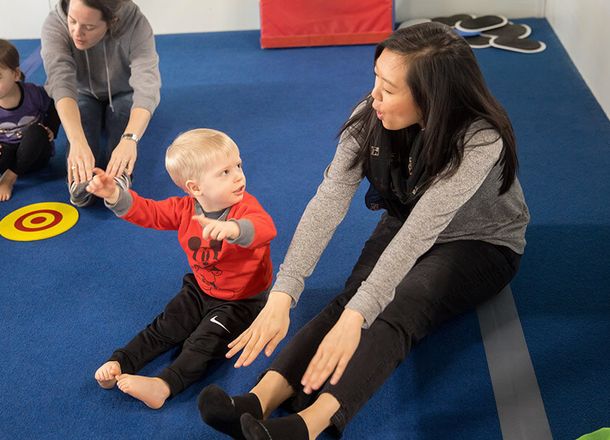 Young child practicing gymnastics with a coach